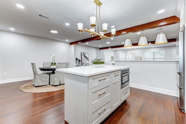 kitchen with dark wood-style floors, beamed ceiling, a chandelier, and a center island