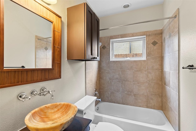 bathroom featuring toilet, a sink, and shower / tub combination