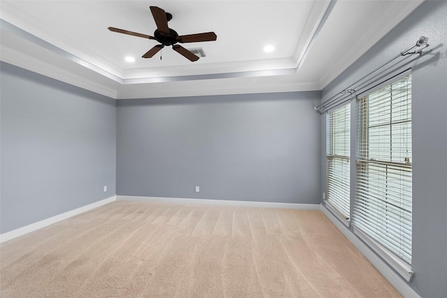 spare room with carpet, baseboards, a tray ceiling, and crown molding