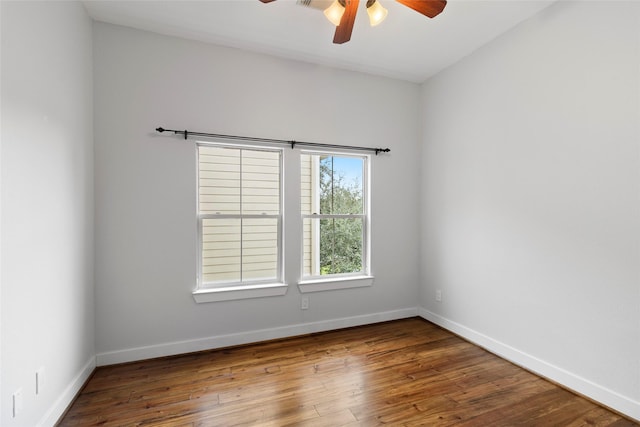 empty room with ceiling fan, baseboards, and wood finished floors