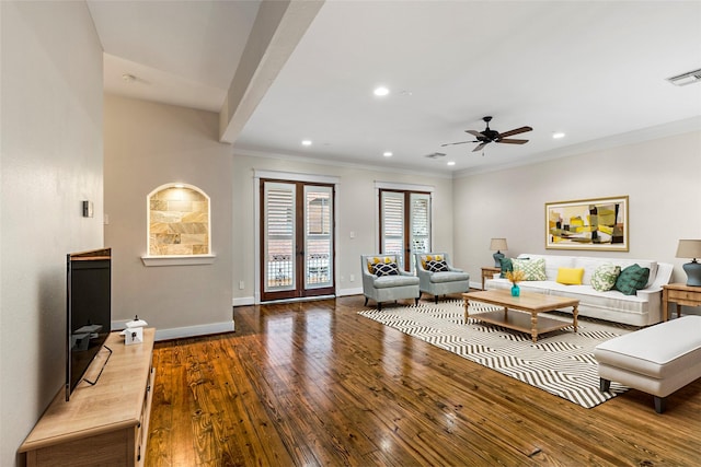 living room featuring crown molding, visible vents, hardwood / wood-style flooring, and baseboards