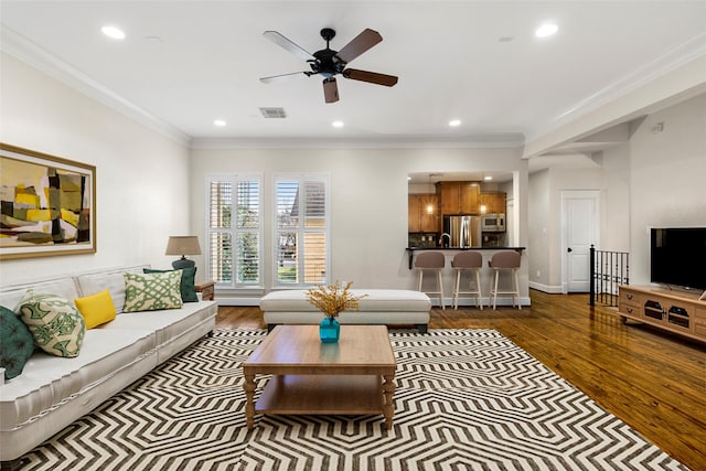 living room featuring ornamental molding and wood finished floors