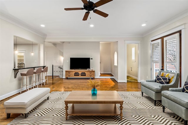 living room featuring ornamental molding, wood finished floors, and baseboards