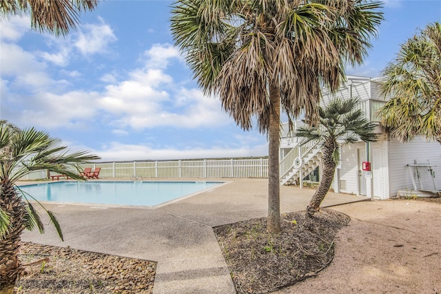 view of swimming pool with a patio, stairway, fence, and a fenced in pool