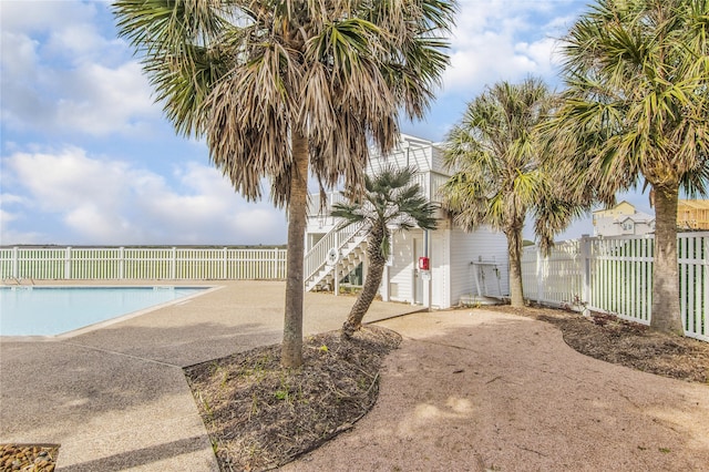 view of swimming pool with stairs, fence, a fenced in pool, and a patio