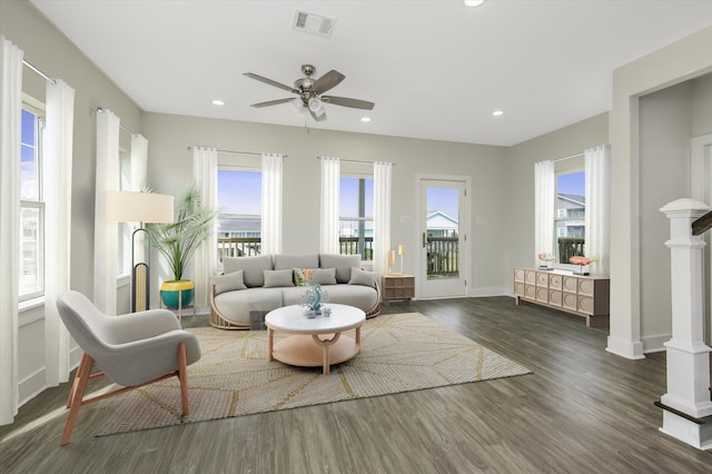 living room with recessed lighting, visible vents, baseboards, and wood finished floors