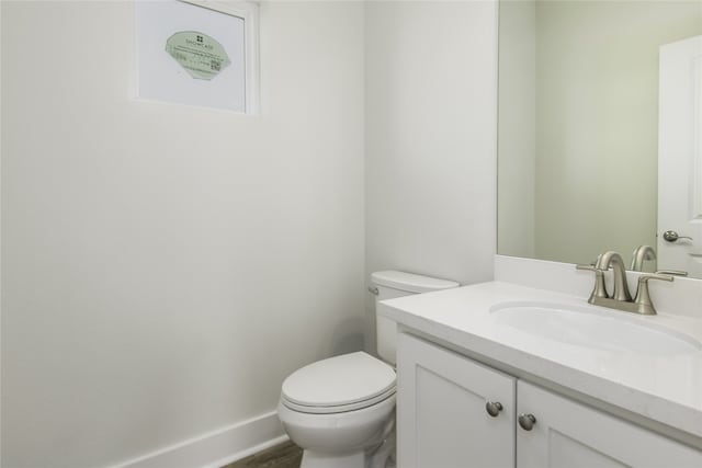 bathroom featuring vanity, toilet, and baseboards