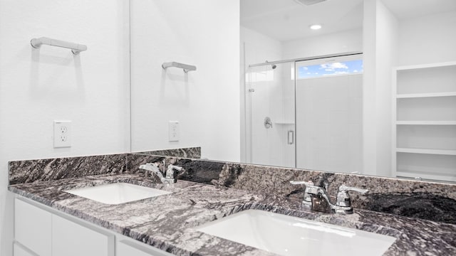 bathroom with a stall shower, visible vents, a sink, and double vanity