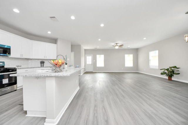 kitchen featuring light wood-style floors, tasteful backsplash, visible vents, and stainless steel appliances