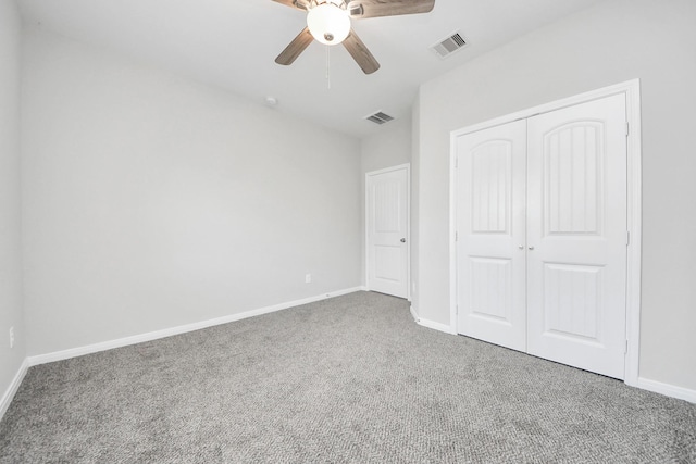 unfurnished bedroom featuring baseboards, carpet, visible vents, and a closet