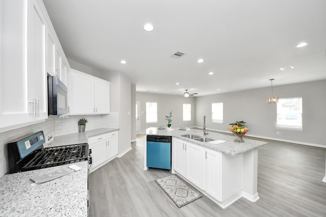 kitchen with black microwave, dishwashing machine, a sink, visible vents, and gas range