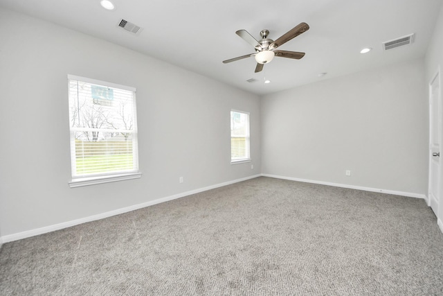 carpeted empty room with plenty of natural light, visible vents, and recessed lighting