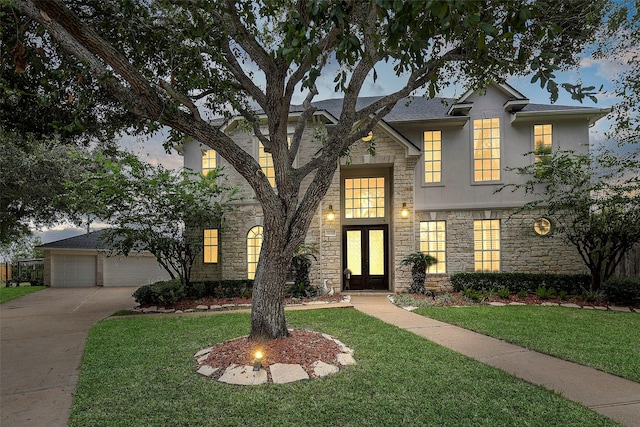 view of front facade featuring stone siding, a lawn, and stucco siding