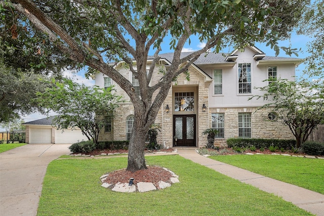 view of front facade with stone siding, stucco siding, french doors, and a front yard