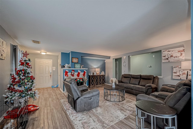 living area featuring baseboards, visible vents, and light wood finished floors