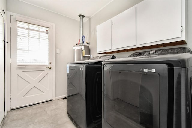 clothes washing area featuring cabinet space, washing machine and dryer, and water heater