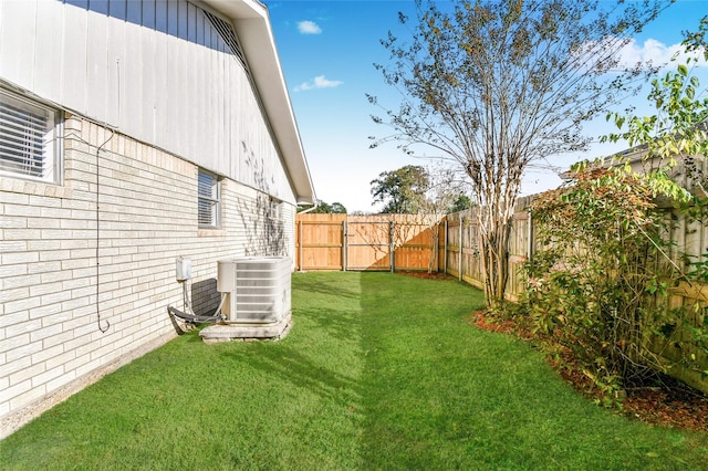 view of yard with central AC unit and a fenced backyard