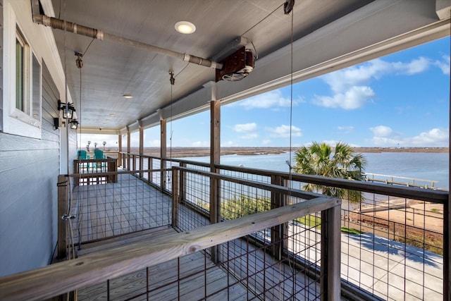 dock area with a water view and a balcony