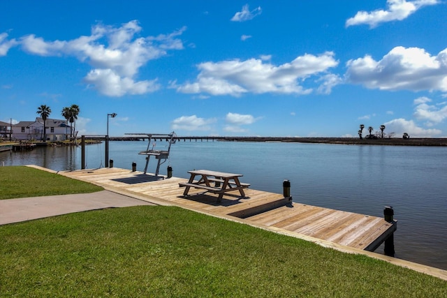 dock area featuring a lawn and a water view