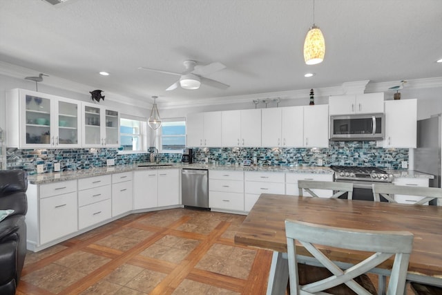 kitchen featuring glass insert cabinets, white cabinetry, stainless steel appliances, and a sink