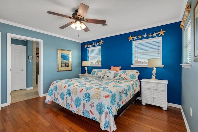 bedroom with baseboards, crown molding, visible vents, and wood finished floors