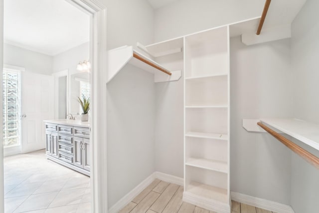 walk in closet with light wood finished floors