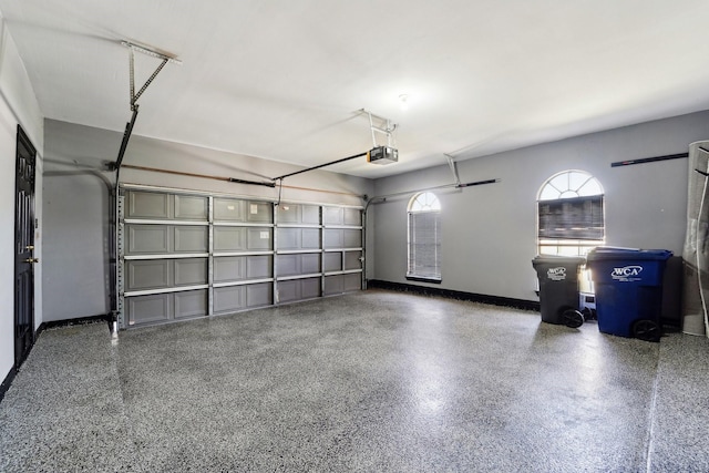 garage with baseboards and a garage door opener