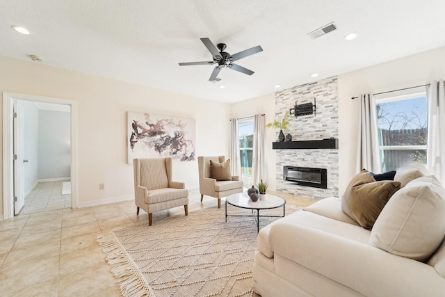 living area featuring a wealth of natural light, visible vents, a fireplace, and light tile patterned floors