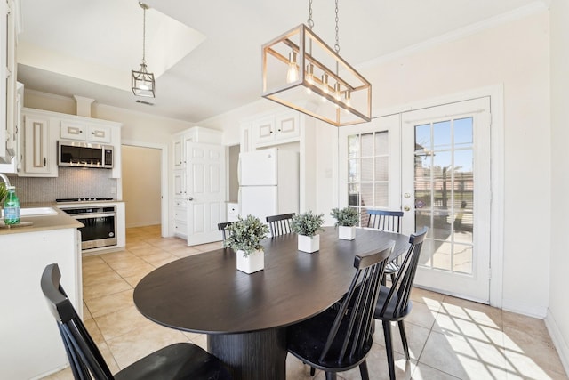 dining space with baseboards, visible vents, ornamental molding, and light tile patterned flooring