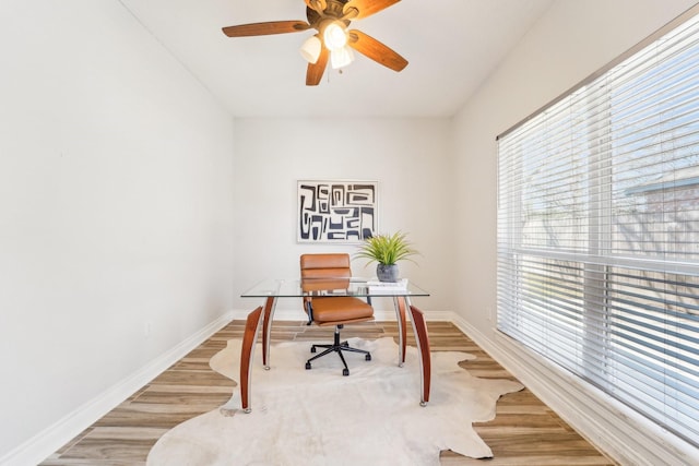 office area with a ceiling fan, baseboards, and wood finished floors