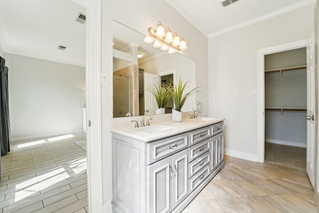 full bath with visible vents, a walk in closet, a sink, and ornamental molding