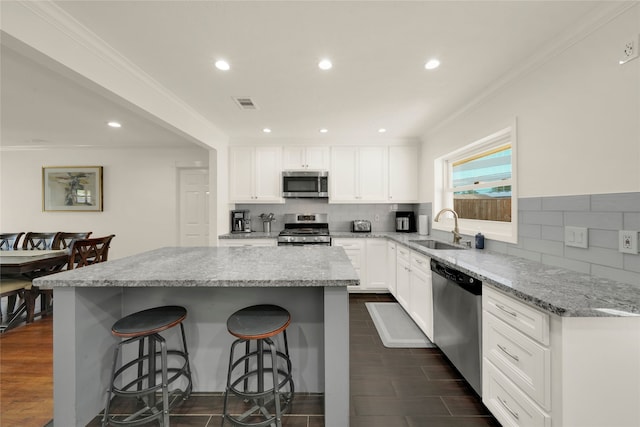 1931 Ansbury Dr, Houston, TX 77018 - kitchen with visible vents, a kitchen breakfast bar, a center island, stainless steel appliances, and a sink