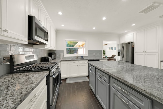 1931 Ansbury Dr, Houston, TX 77018 - kitchen with visible vents, light stone countertops, gray cabinets, stainless steel appliances, and a sink