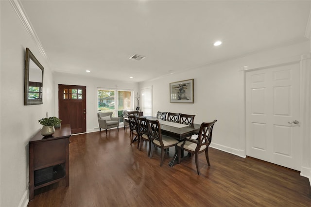 dining space featuring dark wood-style floors, visible vents, crown molding, and baseboards