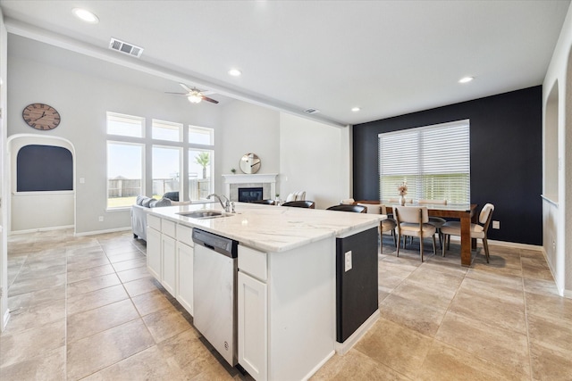 kitchen with visible vents, dishwasher, a glass covered fireplace, open floor plan, and a sink