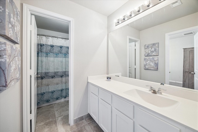 full bath featuring visible vents, vanity, and baseboards