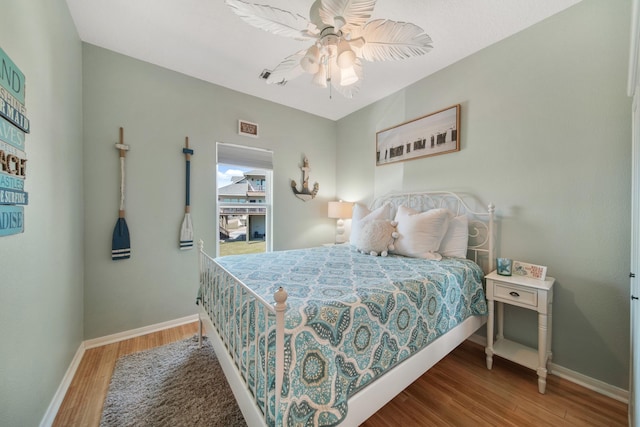 bedroom with ceiling fan, baseboards, and wood finished floors