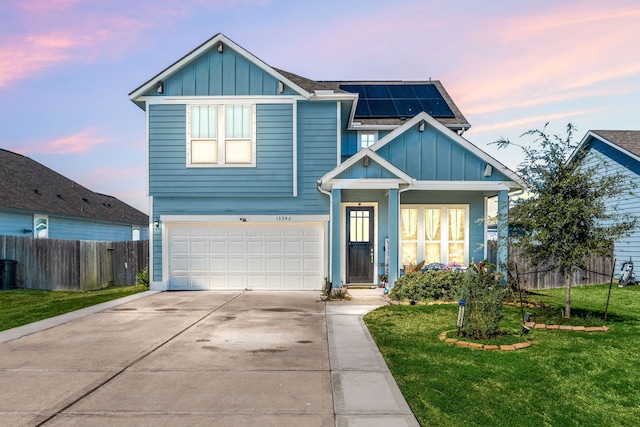 view of front of property with board and batten siding, a yard, fence, and solar panels