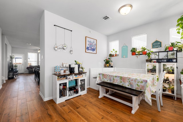 dining room with visible vents, baseboards, and hardwood / wood-style flooring