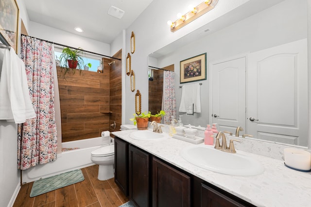 full bath with double vanity, wood finished floors, a sink, and shower / tub combo with curtain