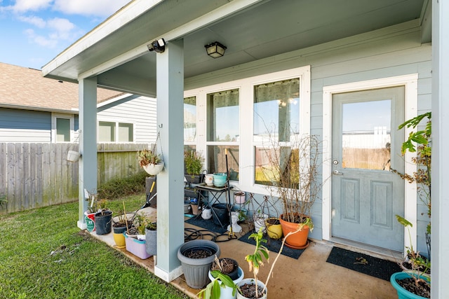 property entrance featuring fence and a lawn