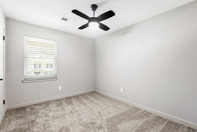 carpeted empty room featuring ceiling fan, visible vents, and baseboards