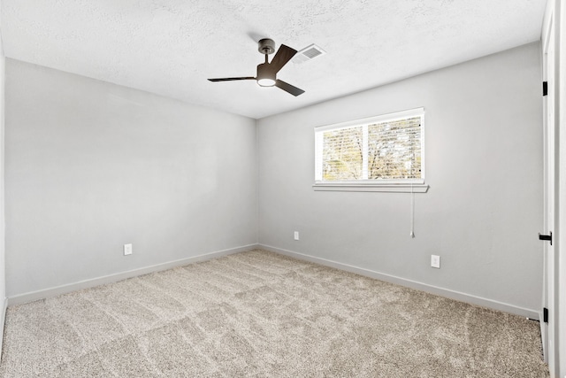 carpeted empty room with a textured ceiling, ceiling fan, visible vents, and baseboards