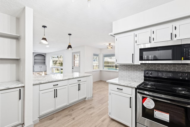 kitchen with electric range, decorative backsplash, light wood-style flooring, stainless steel microwave, and light stone countertops