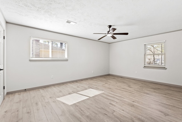 unfurnished room with a healthy amount of sunlight, a textured ceiling, and light wood finished floors