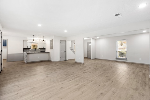 unfurnished living room with light wood-style floors, recessed lighting, visible vents, and baseboards