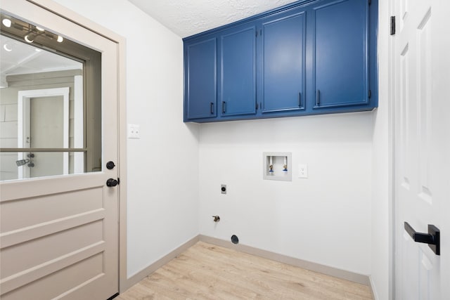 laundry room featuring hookup for an electric dryer, washer hookup, baseboards, light wood-style floors, and cabinet space