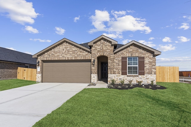 view of front of property with brick siding, concrete driveway, an attached garage, fence, and a front yard