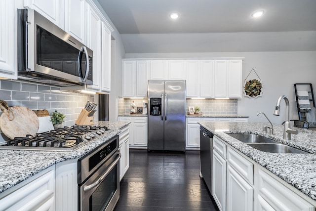 kitchen with dark wood-type flooring, recessed lighting, white cabinets, stainless steel appliances, and a sink