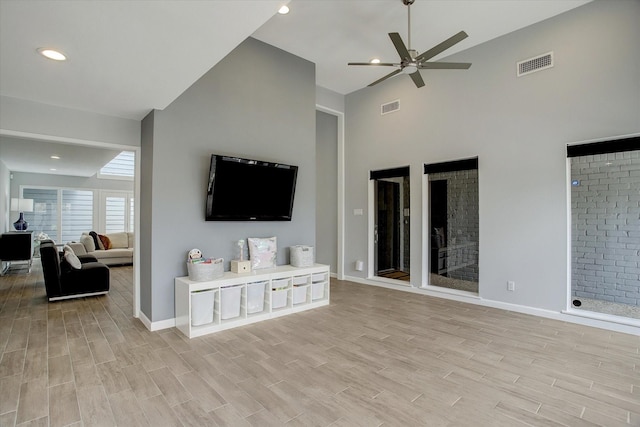 living room with light wood-style floors, visible vents, and baseboards